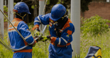 Imagen de técnicos de ENEL Codensa revisando unos cables junto a un poste de luz