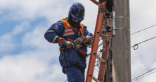 Imagen de un técnico de ENEL realizando mantenimiento en un poste de luz.