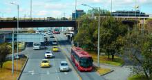 Foto de un bus de TransMilenio junto a otros vehículos en una vía de Bogotá