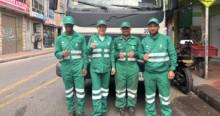 Foto de un grupo de operarios y operarias de aseo en Bogotá, al lado un camión recolector de basuras.