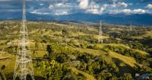 La imagen muestra torres de transmisión de energía en un paisaje rural