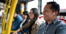 Foto de un hombre en un bus de TransMilenio usando audífonos.