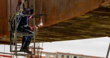 Foto de obreros realizando trabajos en un puente vehicular en Bogotá.