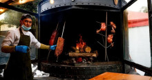 Foto de un hombre frente a un asador de carnes en Bogotá.