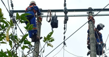 Foto que muestra dos personas con uniforme de Enel Colombia en un poste de luz