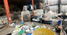 Foto que muestra dos personas con gorros y tapabocas reciclando 