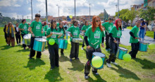 Foto que muestra personas tocando tambores en un parque 