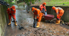 Foto que muestra tres personas con el uniforme de Aguas de Bogotá limpiando un canal
