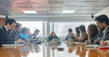 Foto que muestra personas sentadas y reunidas en una sala de juntas
