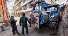 Foto que muestra trabajadores del Acueducto de Bogotá junto a un carro 