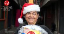 Imagen de beneficiaria con gorro de navidad y mercado por el Banco de Alimentos de Bogotá