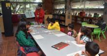 Foto que muestra niños y niñas sentados en una biblioteca