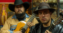 Foto de dos hombres con sombrero y uo coonuna guitarra 