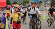 Personas en bicicleta durante Ciclovía en Bogotá acompañadas por Guardianes de la Ciclovía