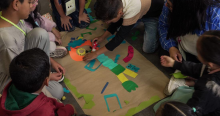 Imagen de grupos de niños creando un personaje con recortes en una cartelera
