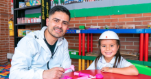 Imagen de un hombre y una niña con casco jugando sobre una mesa en las bibliotecas públicas de Bogotá