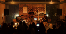 Imagen de la agrupación dando un concierto con sus instrumentos musicales.