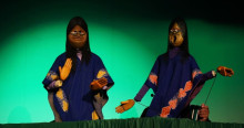Imagen de dos marionetas con rasgos indígenas vestidas con mantas azules 
