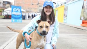 Voluntario de protección animal posando con perro. 