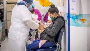 Enfermera atendiendo a mamá y su bebé