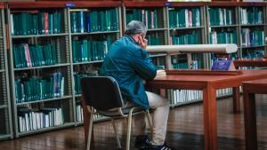 Hombre leyendo un una biblioteca