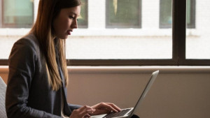 Mujer frente a un computador (Banco de imágenes)