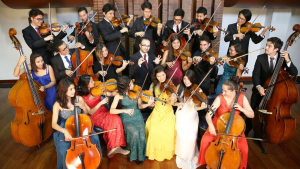 Un grupo de jóvenes interpretan instrumentos de cuerda.