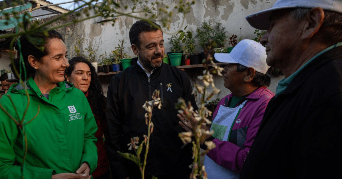 Foto del alcalde Galán hablando con una señora en un jardín