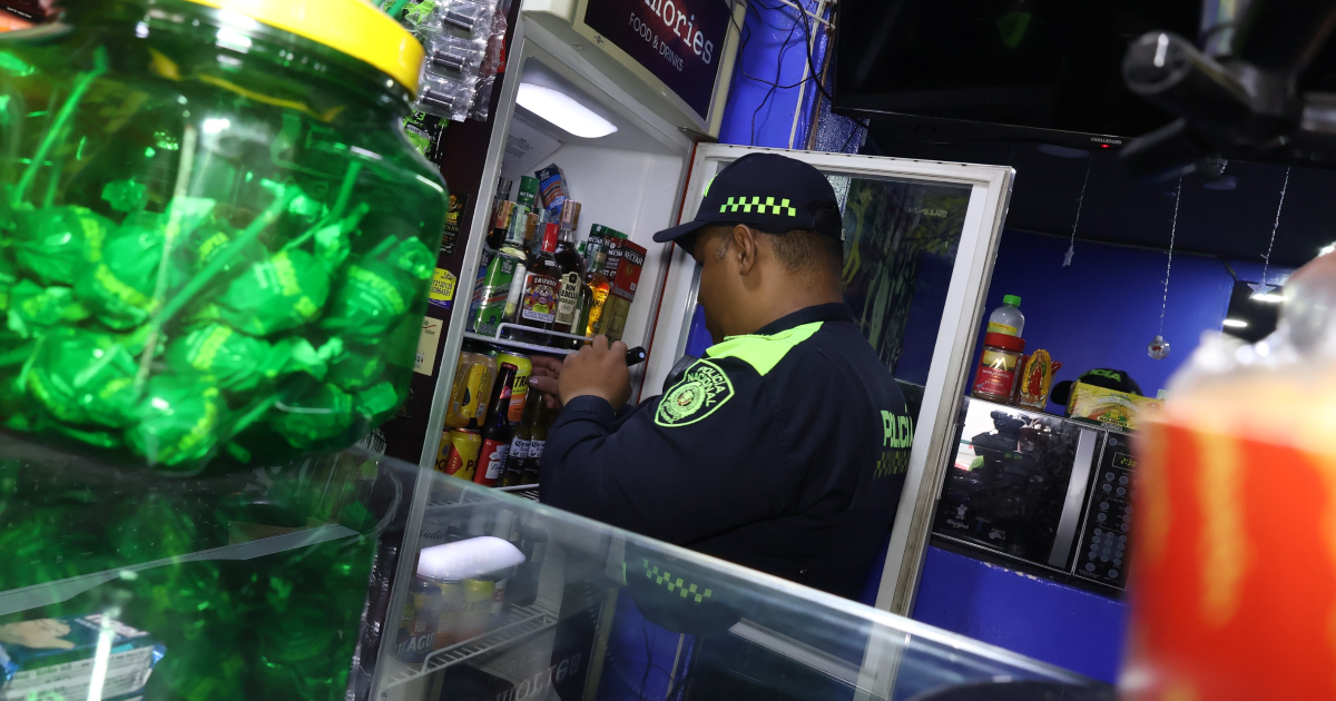 Imagen de un Policía inspeccionando una nevera en un establecimiento comercial