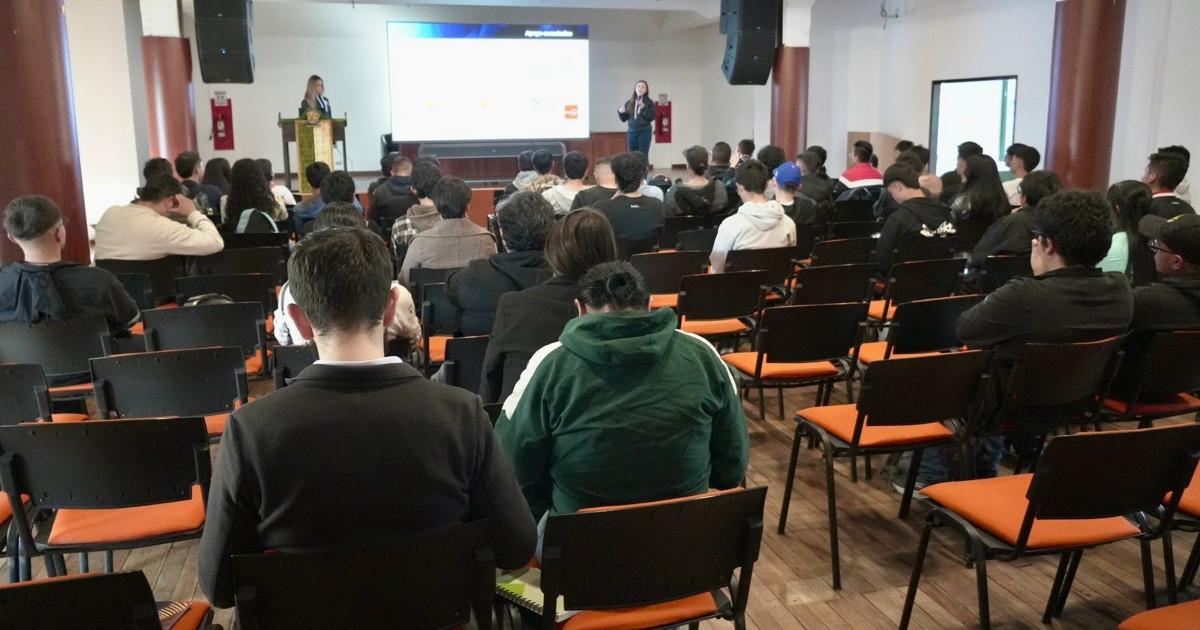 Foto que muestra personas sentadas en una sala 