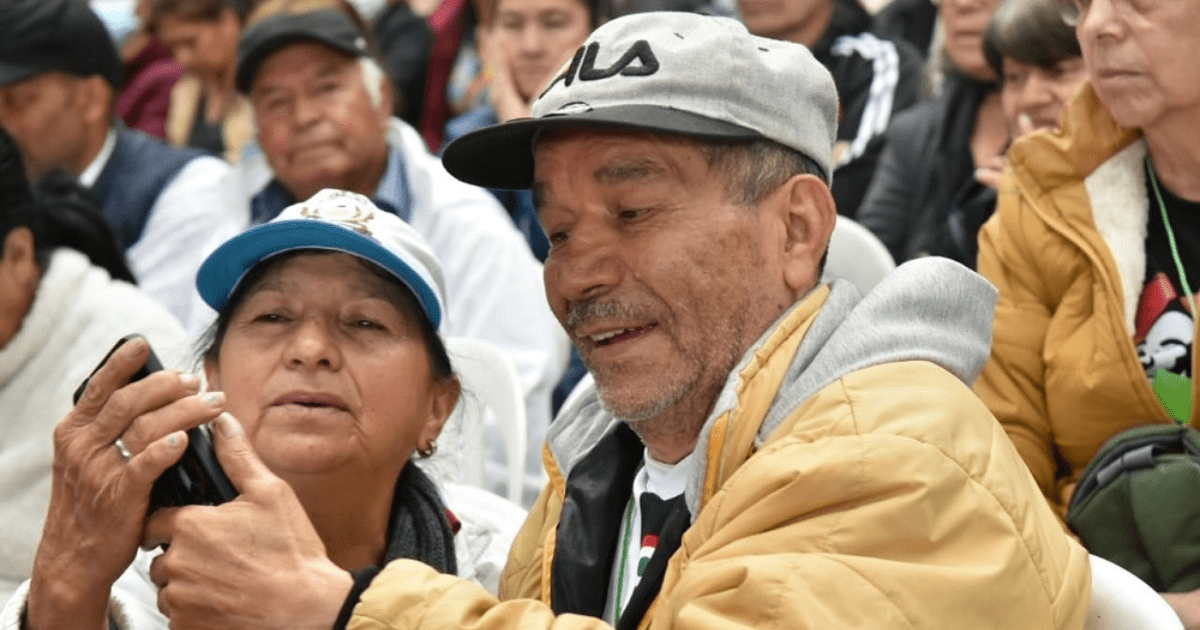 Imagen de dos personas mayores mirando un celular