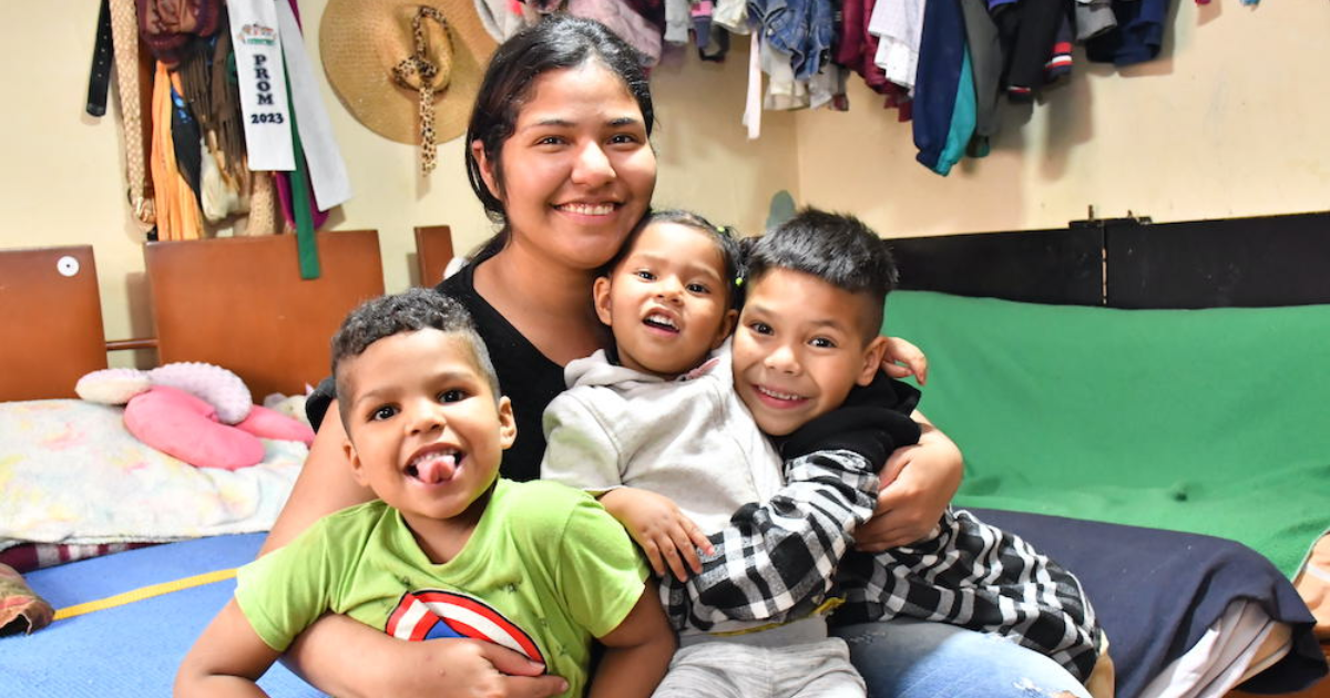 Imagen de una madre sonriendo junto a sus hijos