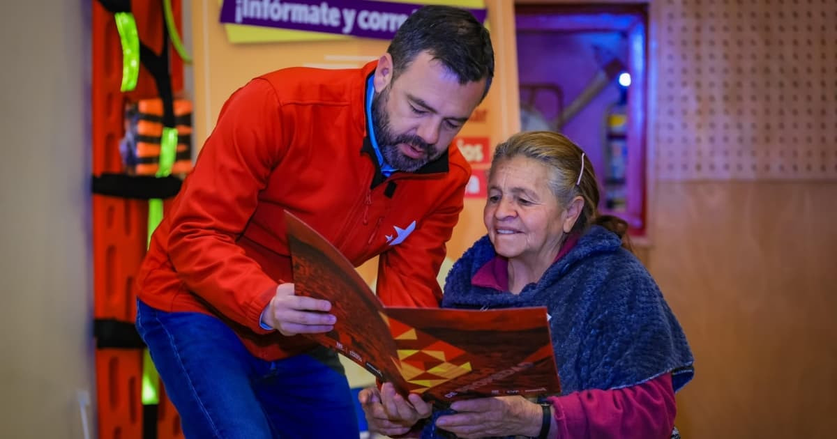 Alcalde Galán entregando el título de propiedad de su vivienda a una señora. 