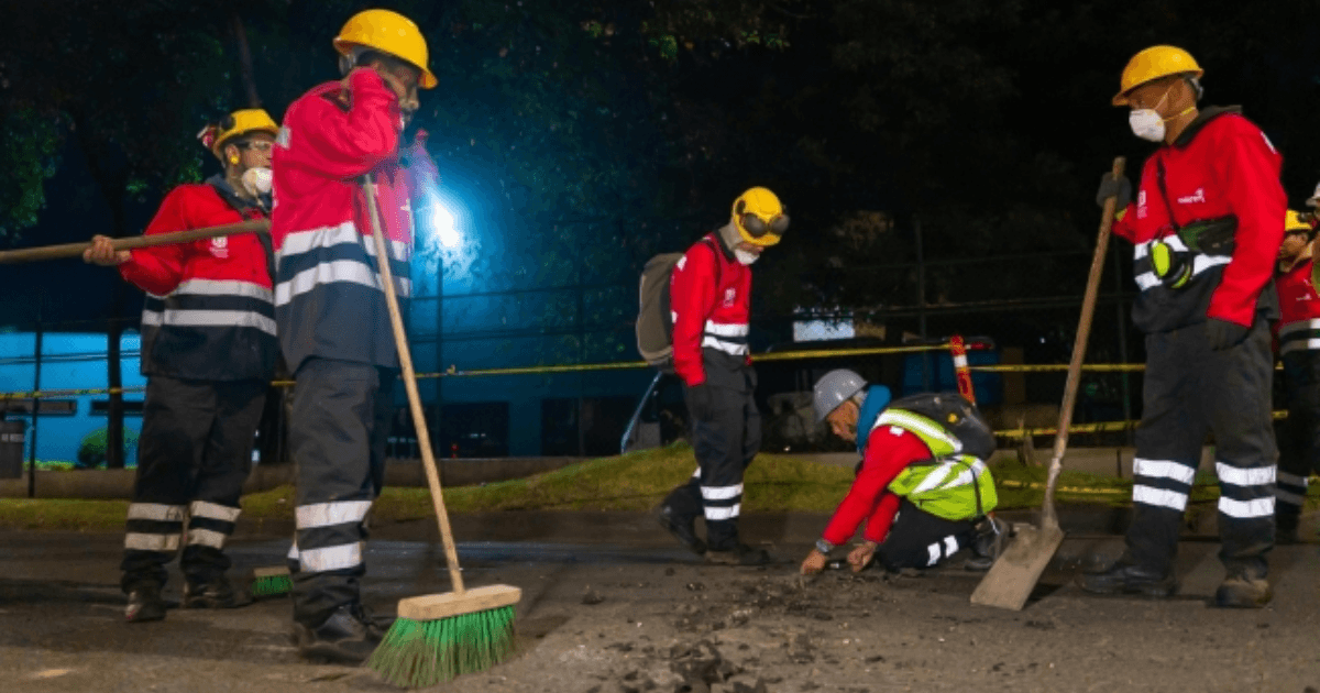 Trabajadores de una obra vial trabajando en la noche.
