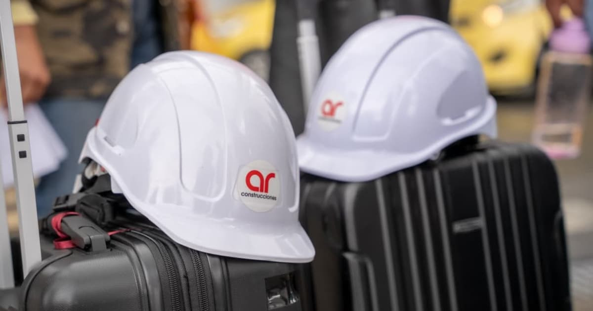 Dos cascos de ingenieros encima de unas maletas de viaje