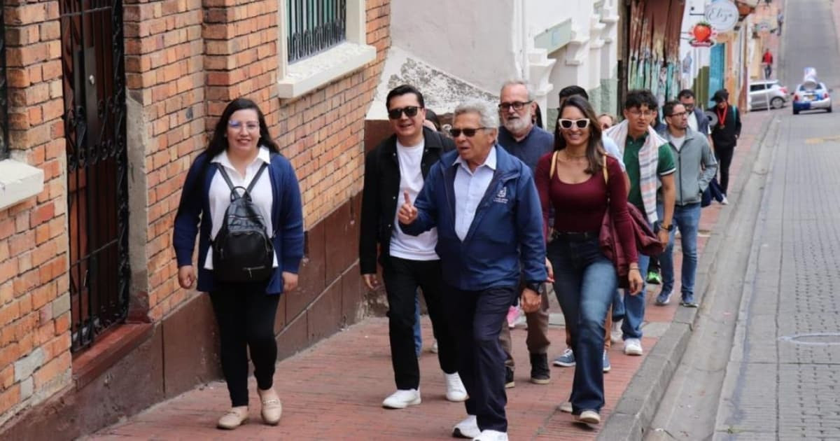 Foto de un guía de turismo, recorriendo las calles del centro de Bogotá con un grupo de turistas.