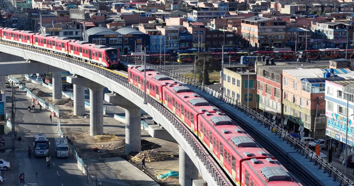Foto de dos trenes de la Línea 1 del Metro de Bogotá, circulando sobre el viaducto.