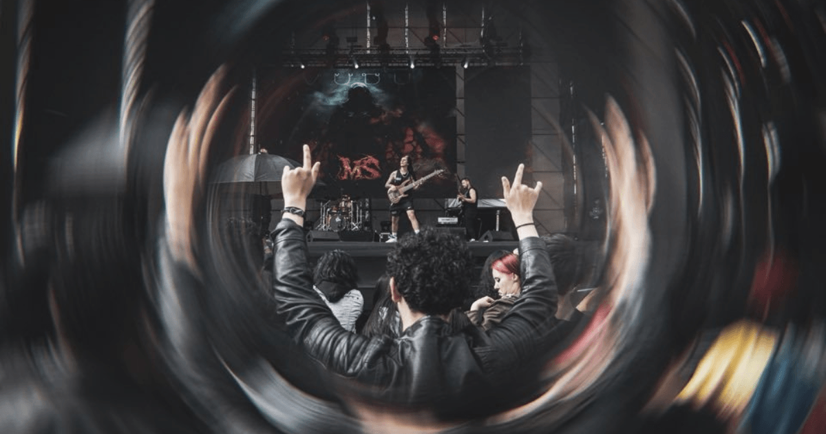 Asistentes observan la presentación de una banda en el escenario principal de Rock al Parque, mientras levantan las manos entre el público frente al espectáculo musical.