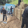 Foto de un equipo de trabajadores que construye un muro de contención