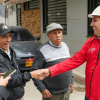 Un funcionario dialoga y estrecha la mano a vecinos del barrio mientras recorren las obras viales en la zona.