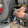 En la foto un señor despinchando una llanta
