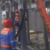 Imagen de tecnicos de Enel que revisan los cables de energía de un poste.