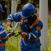 Imagen de técnicos de ENEL Codensa revisando unos cables junto a un poste de luz