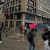 Foto de personas con sombrilla en una calle de Bogotá