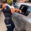 En la foto una mujer policía rescatando al menor de dos años encerrado en un carro 
