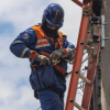Imagen de un técnico de ENEL realizando mantenimiento en un poste de luz.