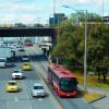 Foto de un bus de TransMilenio junto a otros vehículos en una vía de Bogotá