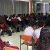 Foto que muestra estudiantes sentados en un salón 