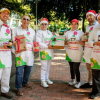 Imagen de varias personas posando para la foto alzando alimentos y con gorros de Navidad