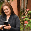 Imagen de frente de una señora viendo un celular